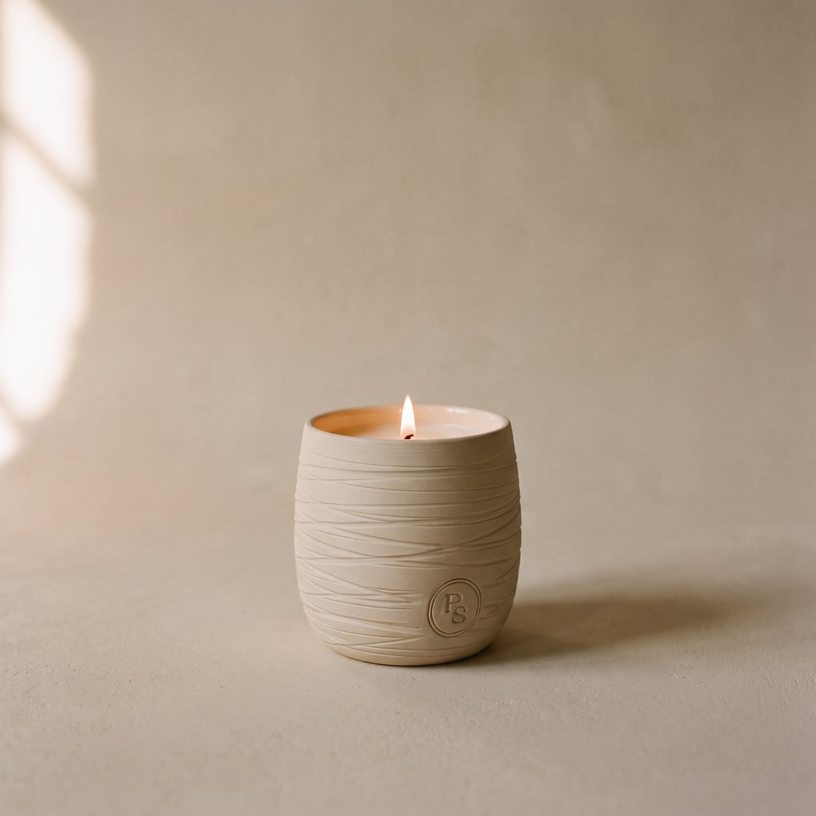 Lit cocosoy candle in its hand-made ceramic vessel
