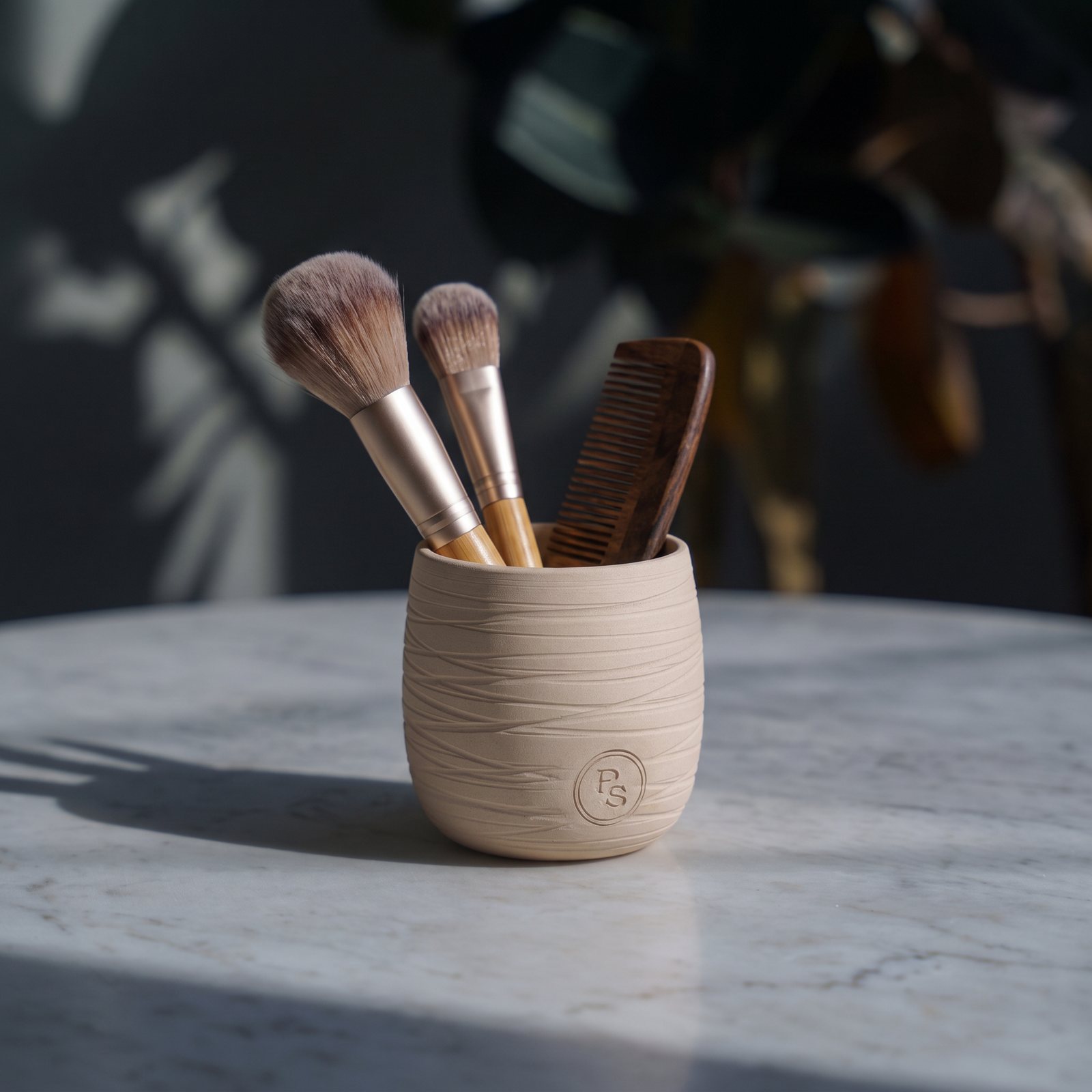 The empty candle vessel reused as a holder for makeup brushes and a comb