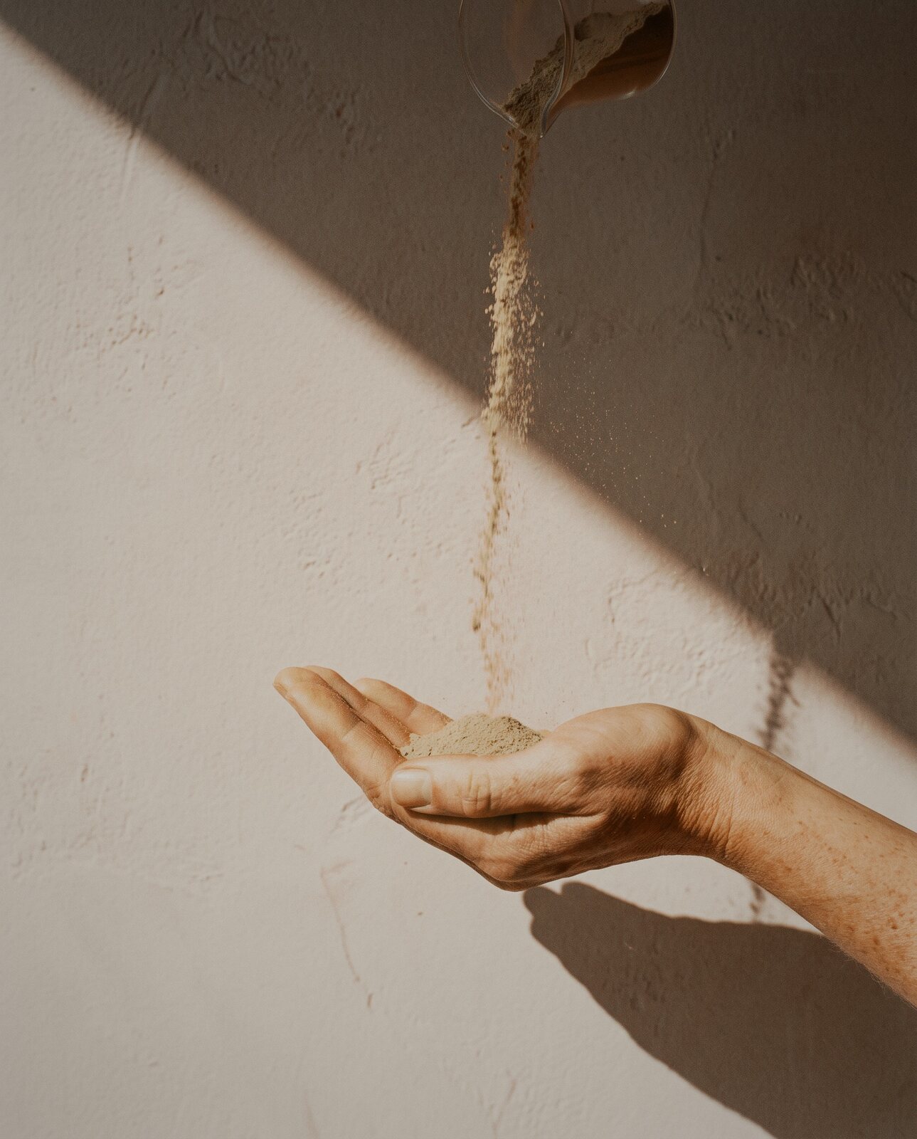 Olive-pit powder poured into an open hand